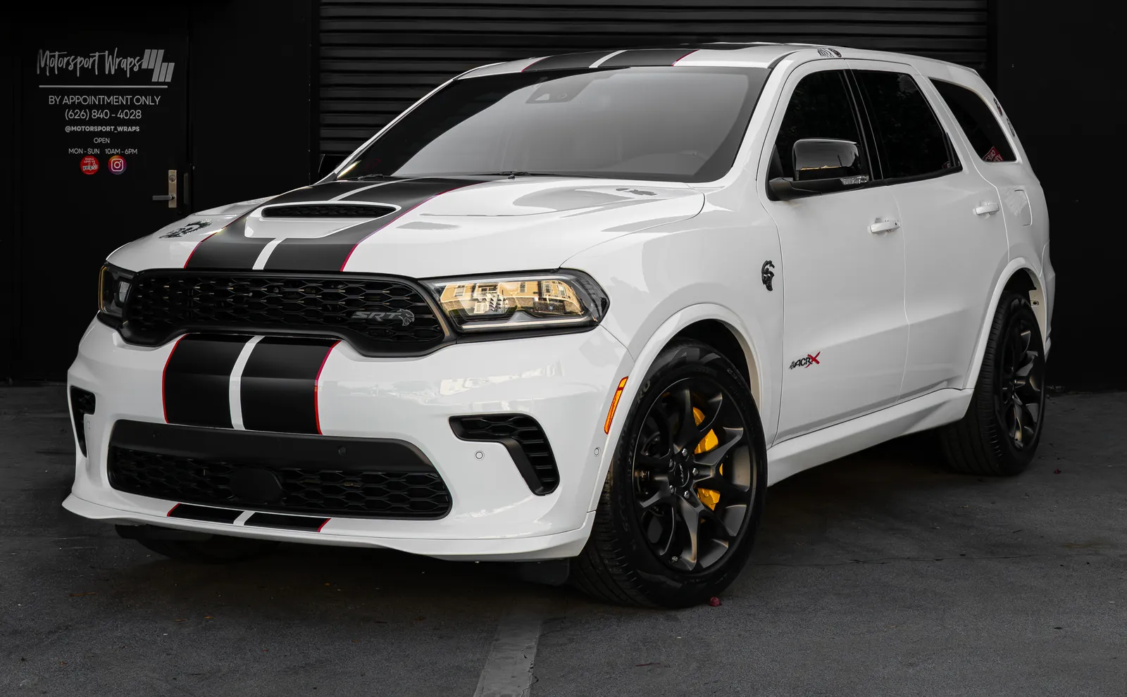 White Dodge Durango SRT with black hood and front stripes and yellow brake calipers, front three-quarter view