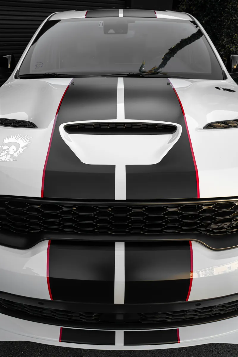 Hood of a white Dodge Durango SRT seen from above with black stripes and hood scoop
