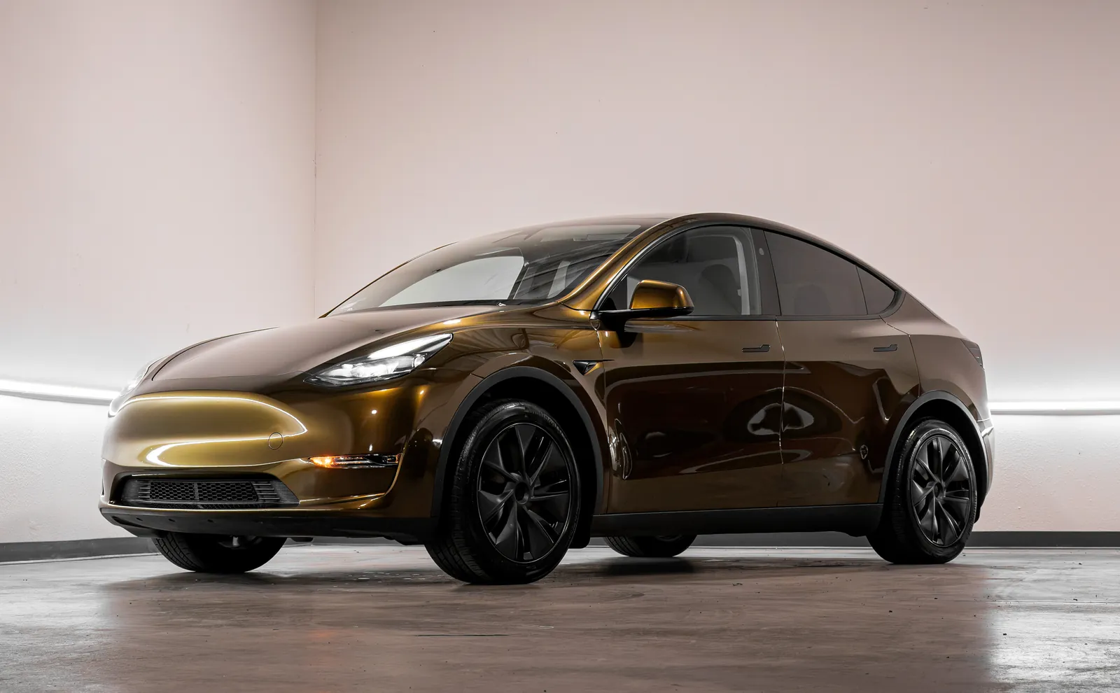 Bronze Tesla Model Y with a color change vinyl wrap, front three-quarter view
